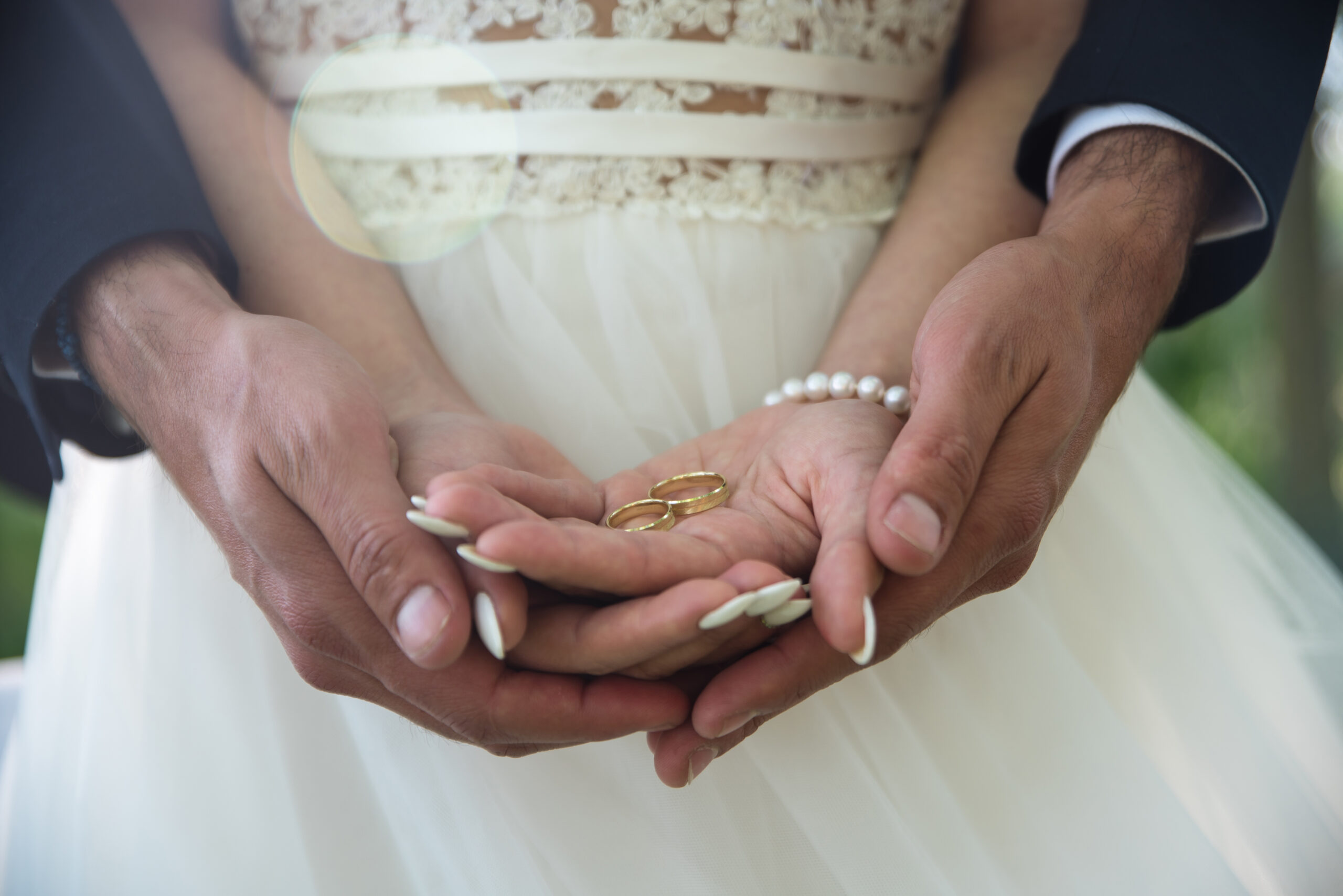 Bride and groom's hands holding golden wedding rings, planning the wedding of your dreams.