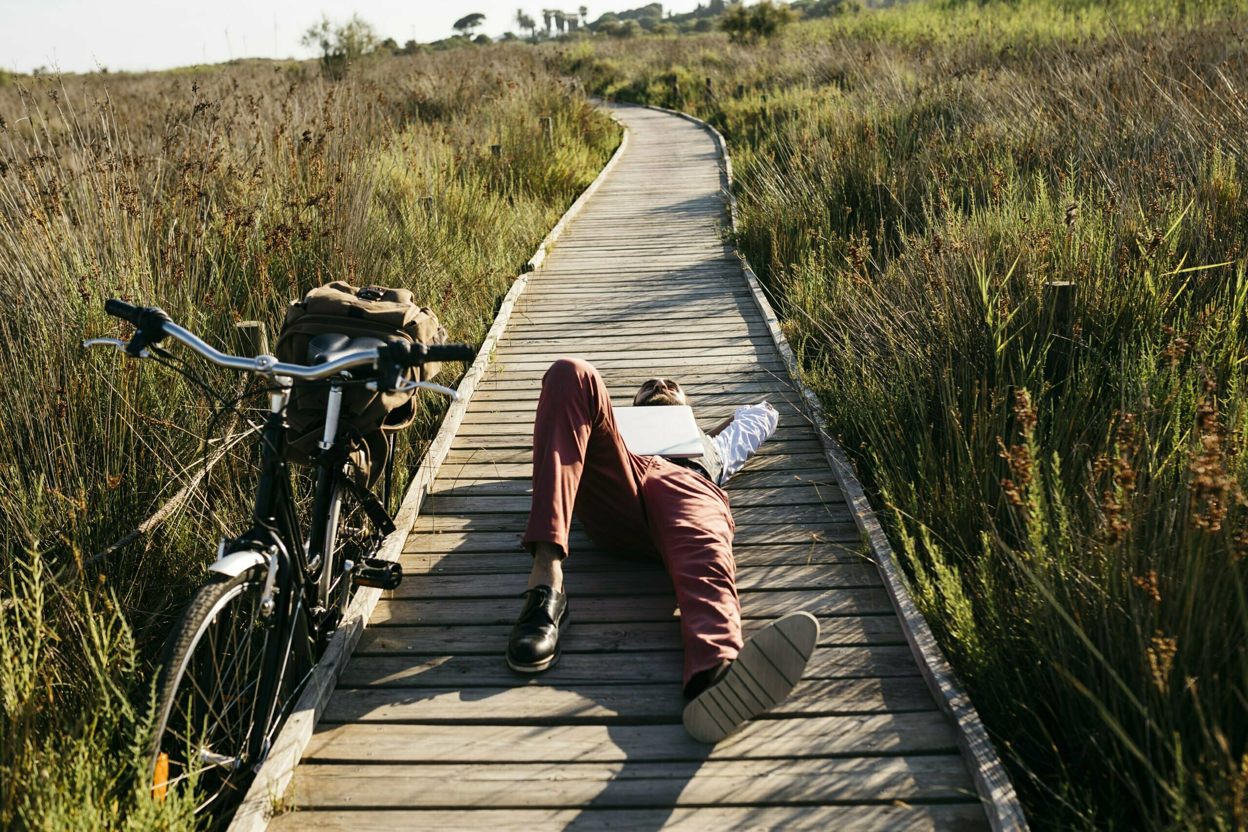 Man with laptop resting on wooden boardwalk, Chevy truck customization inspiration.