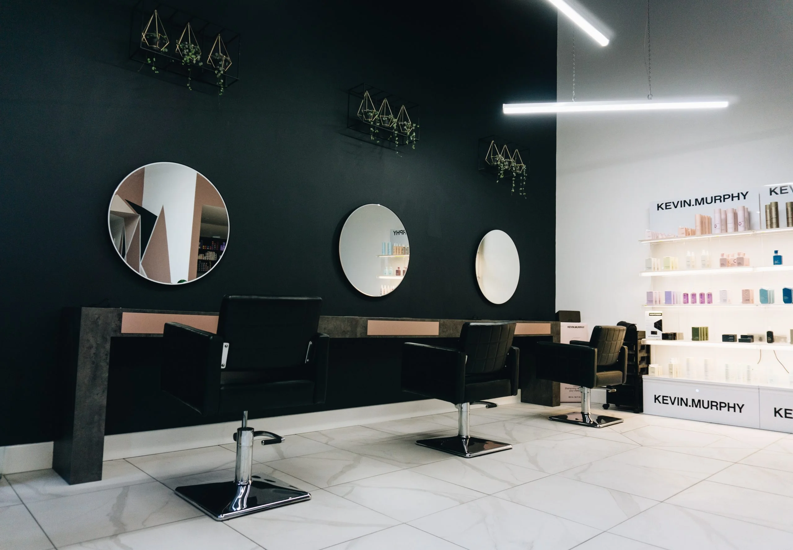 a room with a black screen and chairs and a black wall with white circles on it